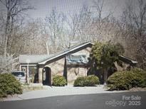 Exterior view of a single-story brick house surrounded by mature trees and bushes at 3700 Nw Gainesway Nw Ct, Concord, NC 28027