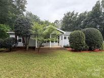Charming single-story home with well-maintained lawn and mature landscaping creates inviting curb appeal at 400 Archibald Rd, Concord, NC 28025