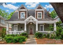 Charming two-story home features a covered porch, lush landscaping, and inviting curb appeal at 417 N Dotger Ave, Charlotte, NC 28204