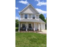 Charming two-story home with a covered front porch, hanging chairs, and beautiful landscaping at 417 Trillium Sw Ct, Conover, NC 28613