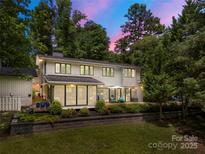 An inviting two-story home, surrounded by lush trees, features a deck perfect for entertaining and enjoying outdoor living at 54 Honeysuckle Woods, Clover, SC 29710