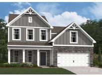 Charming two-story home with gray siding, stone accents, white trim, and a two-car garage at 905 Barker St, Monroe, NC 28112