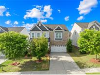 Beautiful two-story home featuring a brick and siding facade, attached garage, and a well-manicured lawn with lush landscaping at 10693 Sky Chase Nw Ave, Concord, NC 28027