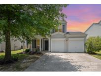 Charming two-story home boasts a well-manicured lawn and two-car garage at 10901 Claude Freeman Dr, Charlotte, NC 28262