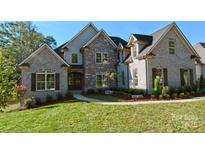 Beautiful two-story brick home featuring a well-manicured lawn and charming architectural details at 1921 Notchwood Ct, Clover, SC 29710