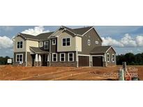 Charming two-story home featuring a two-car garage and a mix of stone and siding accents at 2522 Mabel Ln, Monroe, NC 28110
