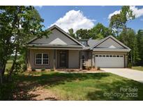 Charming single-story home with a two-car garage and a well-manicured lawn on a sunny day at 3011 Buffett Ln # 33, Monroe, NC 28110