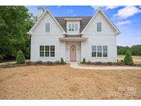 Charming two-story home with white siding, complemented by a well-manicured lawn and inviting walkway at 3622 E Brief Rd, Monroe, NC 28110
