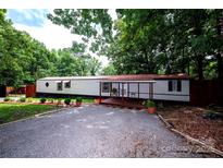 Charming single-story home featuring a covered porch, gravel driveway, and mature landscaping at 475 Dot Faris Rd, Catawba, SC 29704