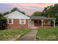 Charming single-story brick home featuring a quaint front porch and well-maintained front yard at 506 7Th Sw St, Hickory, NC 28602