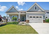 Charming home featuring a manicured lawn, welcoming front porch, and attached two-car garage at 6136 Sandy Point Ln, Belmont, NC 28012