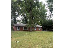 Charming brick home featuring a large, grassy front yard with mature trees offering ample shade at 6419 Prett Ct, Charlotte, NC 28270