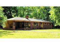 Charming brick ranch-style home featuring a covered porch, large windows, and a well-maintained lawn at 824 Kentberry Dr, Charlotte, NC 28214