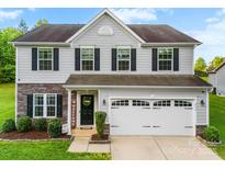 Charming two-story home featuring gray siding, stone accents, and a well-maintained front yard at 865 Wingthorn Rose Dr, Gastonia, NC 28056