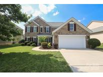 Charming two-story brick home with a well-manicured lawn and a two-car garage at 10217 Falling Leaf Dr, Concord, NC 28027