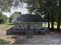 Charming home with a covered front porch, brick detail, and mature trees at 1105 Horton Ave, Kannapolis, NC 28083