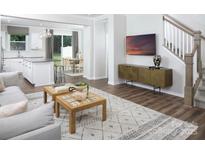 Inviting living room with hardwood floors, patterned rug, and modern decor; open to kitchen and dining area at 12309 Gambrell Dr, Charlotte, NC 28278