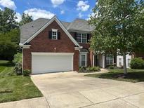 Charming two-story brick home with an attached two-car garage and beautifully landscaped front yard at 13123 Ashley Meadow Dr, Charlotte, NC 28213