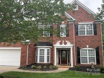 Charming two-story brick home with a manicured front yard, black shutters, and inviting entrance at 13123 Ashley Meadow Dr, Charlotte, NC 28213
