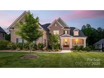 Charming brick home featuring a manicured lawn, elegant entrance, and inviting front porch at 1445 Cherry Laurel Dr, Waxhaw, NC 28173