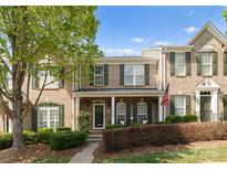 Charming brick townhome featuring a covered front porch and well-manicured landscaping at 19143 Juanita Ln, Cornelius, NC 28031