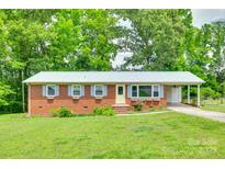 Charming brick home with a metal roof, tidy landscaping, and a covered carport at 2833 Regency Rd, Lancaster, SC 29720