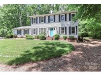 Charming two-story home with a manicured lawn and a lovely blue front door and mature trees at 417 Florence Cir, Statesville, NC 28625