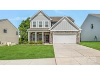 Charming two-story home with a well-manicured lawn, stone accents, and a two-car garage, offering great curb appeal at 699 Kitfox Nw Dr, Concord, NC 28027