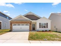 Charming single-Gathering home with a two-car garage, brick accents, and a well-manicured lawn at 9037 Remnick Dr, Gastonia, NC 28056