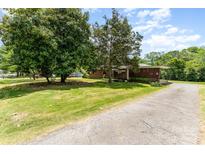 Charming single-story home with a covered carport, lush lawn, and mature trees adding curb appeal at 1102 E 13Th St, Kannapolis, NC 28083