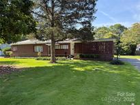 Charming single-story brick home with a well-manicured lawn, mature trees, and inviting front entrance at 1102 E 13Th St, Kannapolis, NC 28083