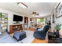 Inviting living room featuring a cozy fireplace, plush seating, and hardwood floors, creating a warm atmosphere at 1102 E 13Th St, Kannapolis, NC 28083
