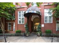 Inviting brick building entrance with awning and manicured landscaping offering a warm welcome at 1320 Fillmore Ave # 426, Charlotte, NC 28203