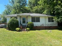 Quaint single-story home featuring a well-maintained lawn, mature landscaping, and an inviting front porch at 146 Center St, Chester, SC 29706
