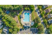 Aerial view of the community pool, playground, and parking area on a sunny day at 1707 Kashmir White Ln, Fort Mill, SC 29708