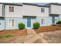 Charming townhome featuring a painted facade, complemented by lush green bushes, and individual front entrances at 1905 Mereview Ct # 21, Charlotte, NC 28210