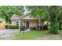 Charming single-story home with light yellow siding, quaint front porch, and mature landscaping at 2212 Acme Rd, Belmont, NC 28012