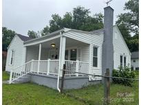 Charming single-story home with a covered front porch, white siding, and a brick chimney at 247 E Cabarrus Ave, Concord, NC 28025