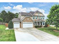 Charming two-story home with a three-car garage, stone accents, and a well-manicured lawn at 3029 Allendale Dr, Fort Mill, SC 29707