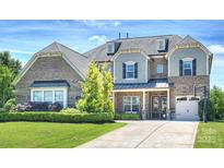 Charming brick home boasts beautiful landscaping, manicured lawn, and a welcoming driveway at 305 Decanting Ln, Fort Mill, SC 29707