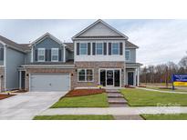 Charming two-story home with a brick and stone facade, attached garage, and inviting front lawn at 4224 Steel Way, Sherrills Ford, NC 28673