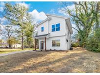 Modern two-story home featuring white siding, a covered front porch, and a well-manicured lawn at 424 Airline Ave, Shelby, NC 28150