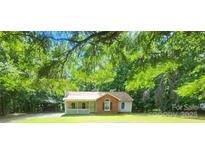Charming single-Gathering home featuring a cozy front porch and a brick facade surrounded by mature trees at 4409 Homestead Rd, Rock Hill, SC 29732