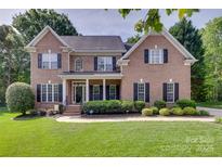 Charming brick two-story home featuring a manicured lawn and traditional architectural details at 9217 Tenby Ln, Matthews, NC 28104