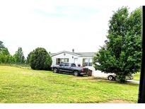 Charming single story home on a large lot featuring a lush green lawn and mature trees and a truck in the driveway at 103 Amy Dr, Kings Mountain, NC 28086