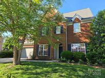Charming brick home boasts a well-manicured lawn, beautiful landscaping, and a classic architectural design at 10418 Goosefoot Nw Ct, Concord, NC 28027