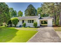Charming white brick home with a covered carport and a well-manicured front yard at 1423 Ebinport Rd, Rock Hill, SC 29732