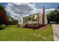 Charming home featuring a brick chimney, inviting front porch, and well-maintained lawn at 1423 N New Hope Rd, Gastonia, NC 28054