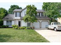 Charming two-story home featuring a manicured lawn, mature landscaping, and a two-car garage with a vintage pickup truck at 14406 Gadwall Ct, Charlotte, NC 28273