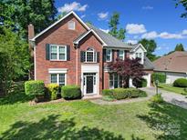 Stunning two-story red brick home with black shutters and manicured landscaping creates wonderful curb appeal at 1506 Ivy Bluff Way, Matthews, NC 28105